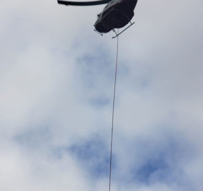 Flying helicopter with a hanging rope tied to it