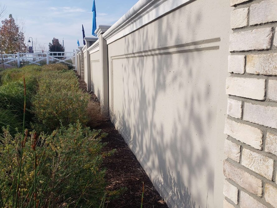 Precast concrete sound barrier wall surrounding residential community.