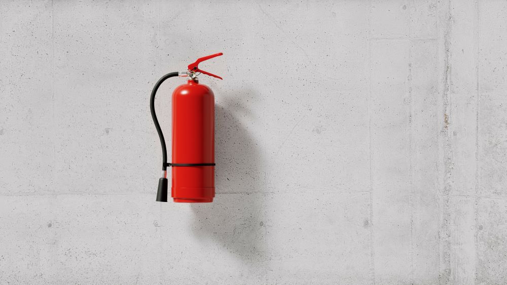A fire distinguisher isolated on a concrete wall.