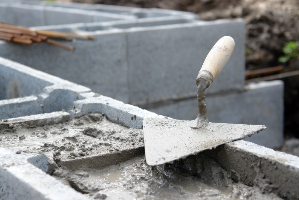 A precast concrete hollow block wall being filled with a concrete mixture to ensure the durability and strength of the blocks.