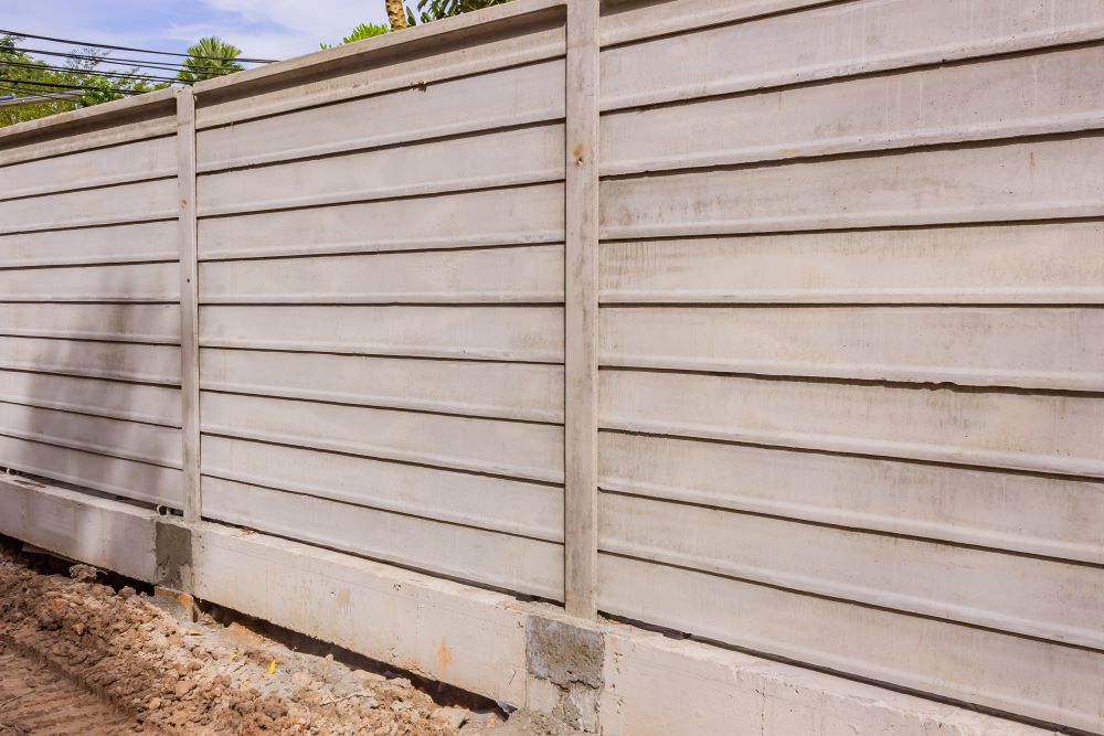A precast concrete wall protecting a residential community from environmental accidents such as mudslides.