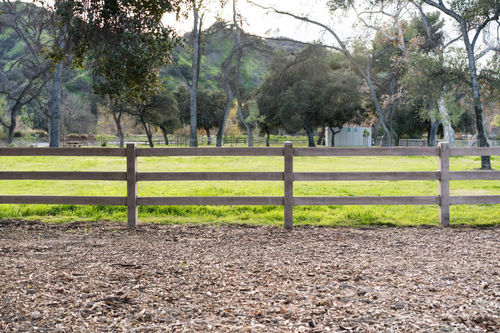 A precast concrete ranch rail fence surrounding the perimeter of a property.