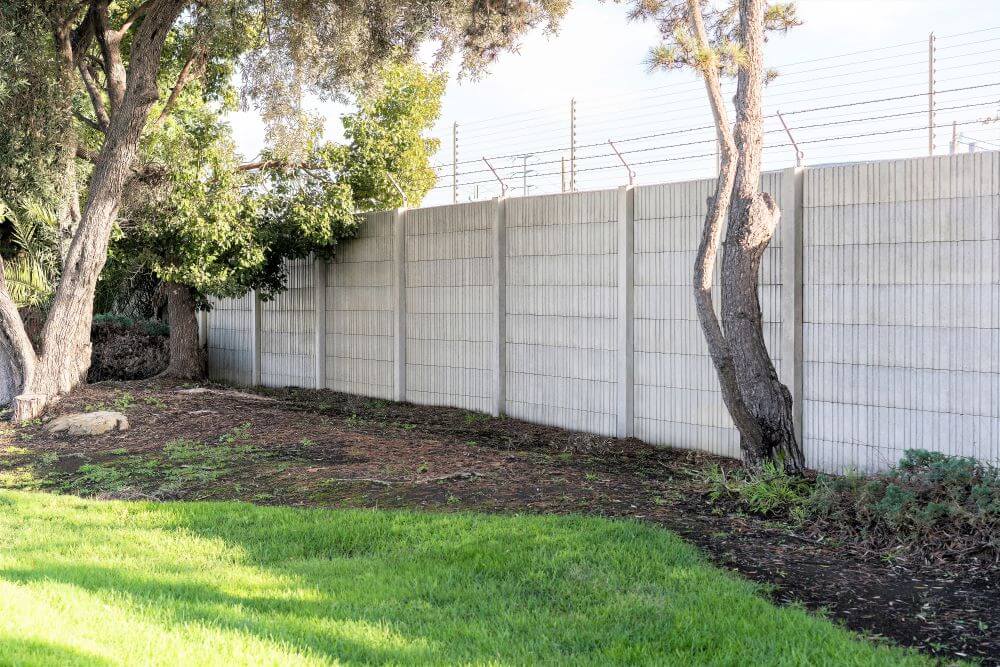 Precast concrete security fence surrounding the perimeter of a property.