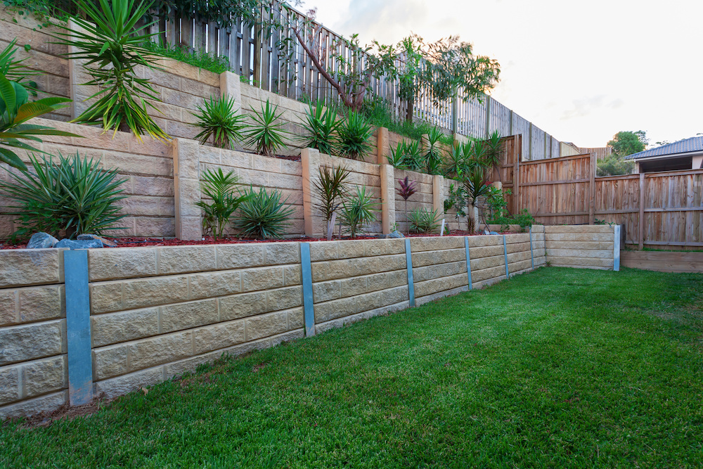 Multi level retaining wall with plants in backyard
