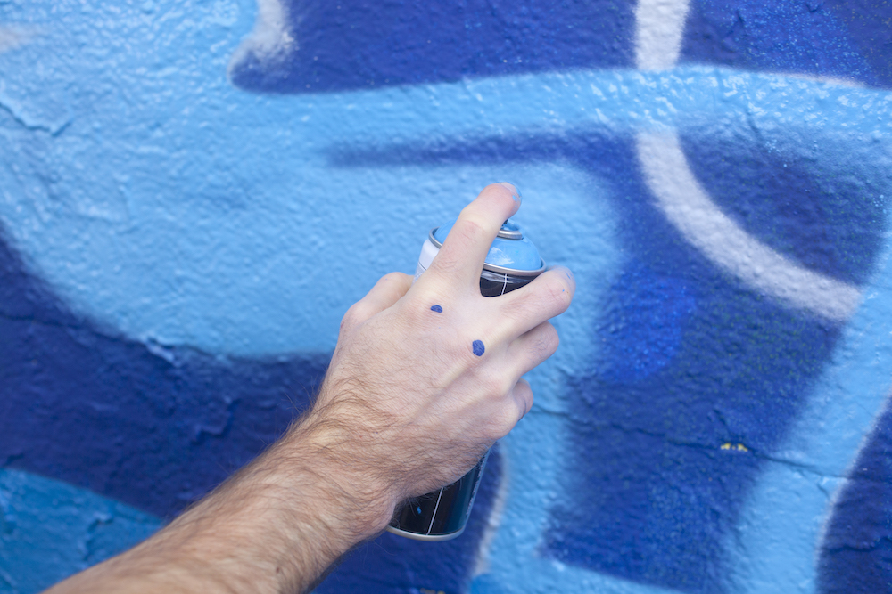 Man holding blue spray paint